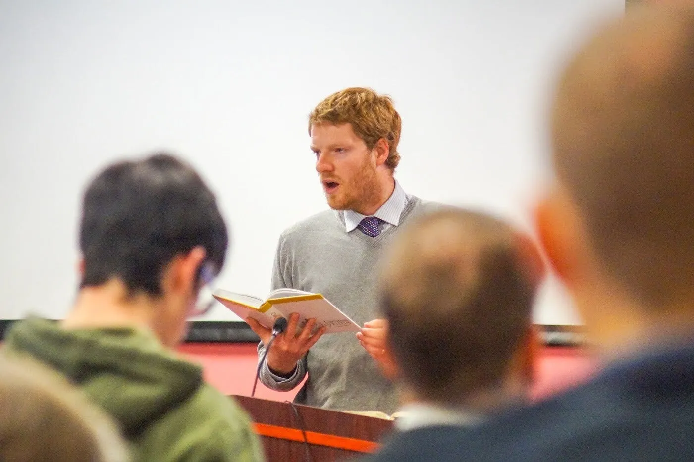 The pastor leading the singing from a hymnbook