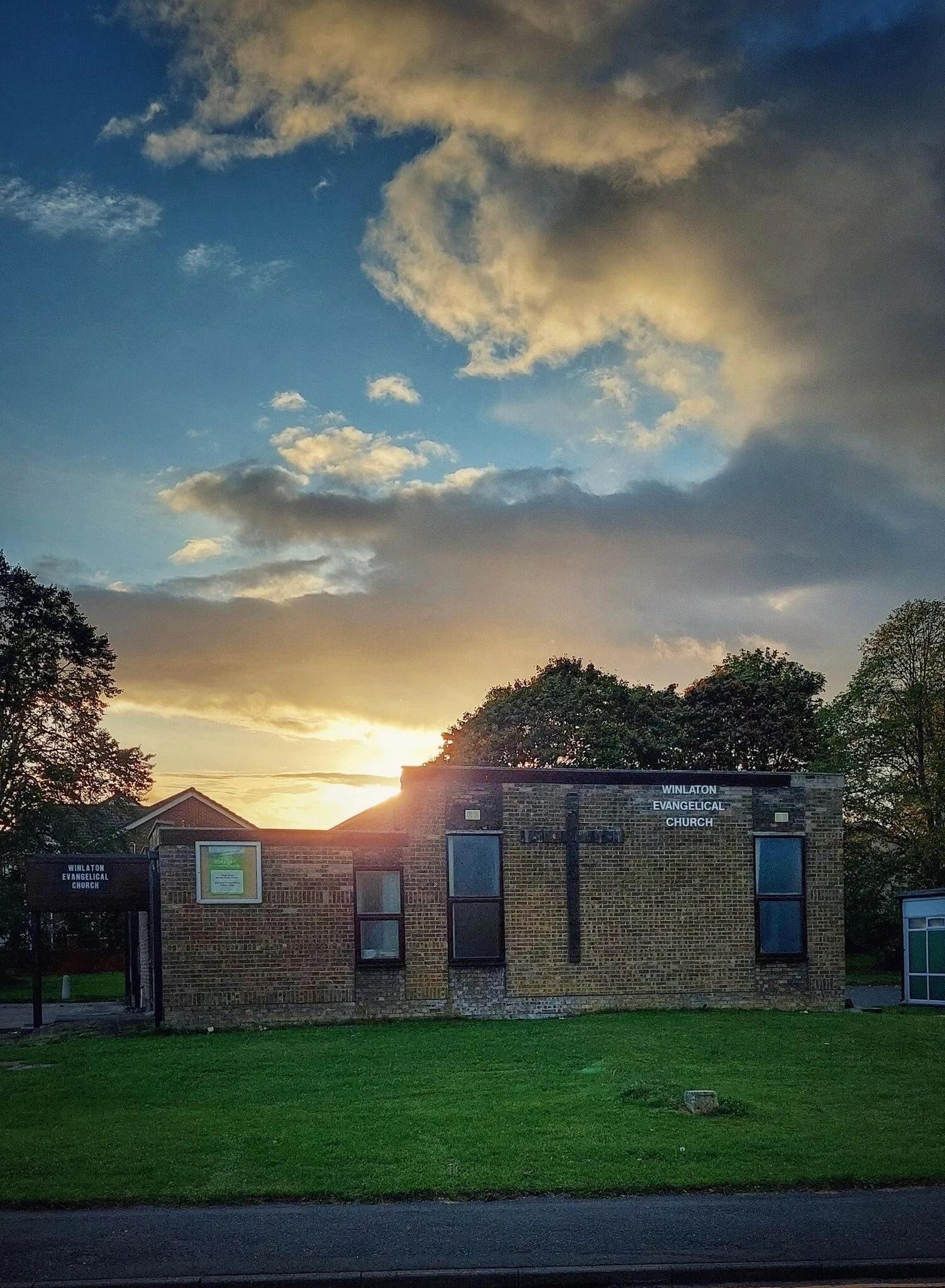 The church building at sunset, the sky lit gold behind it